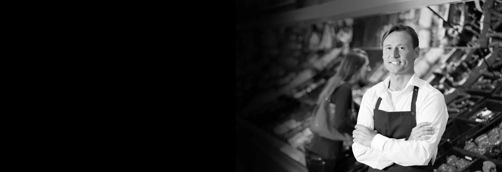 Smiling grocery worker in uniform standing confidently in the produce aisle — representing GEKLAW’s advocacy for California workers injured on the job.